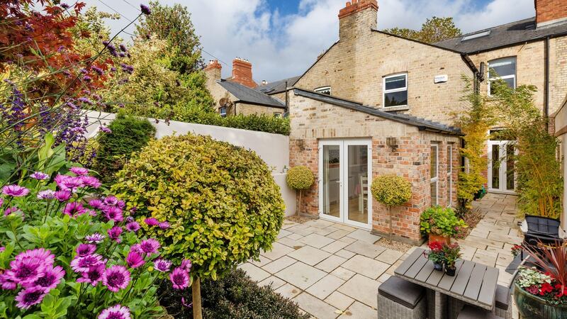 The doors open out to a valuable south-facing flagstone patio and a garden landscaped by Garden Transformation that is stepped to the back, rising to meet the southern aspect sunlight.