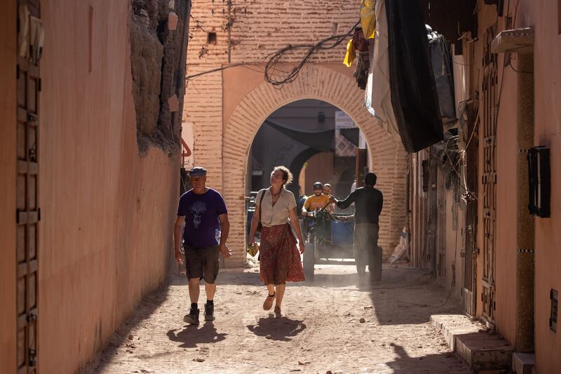 Tourists walk past a building damaged by the earthquake in Marrakech. Photograph: Jerome Favre/EPA