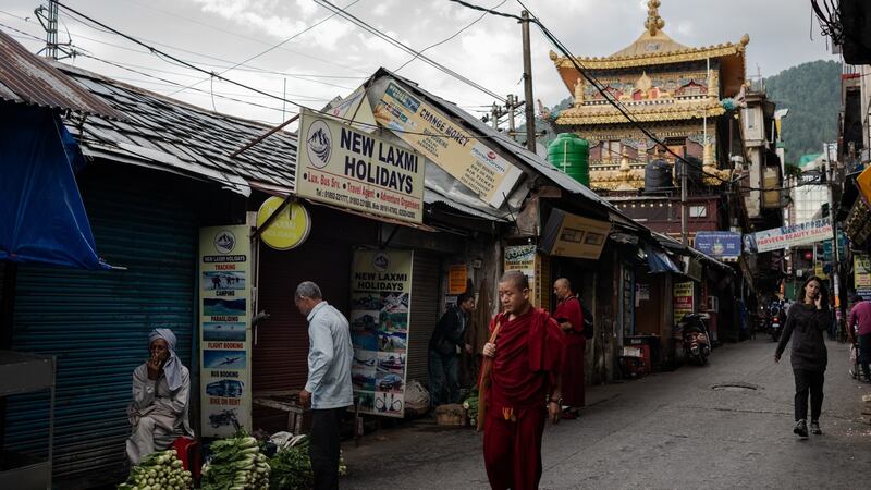 Visitors and Tibetan monks walk past the Kalachakra Temple in Daramshala, India. Photograph: Rebecca Conway/The New York Times