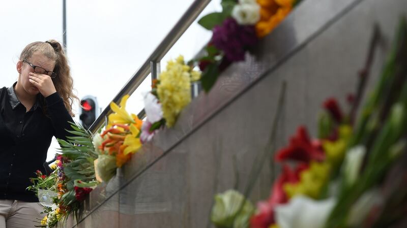 A young woman mourns at an underground station near the Olympia-Einkaufszentrum shopping centre on Saturday. Photograph:  Christof Stache/AFP
