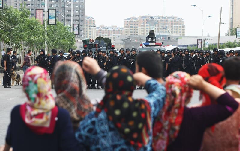 Uyghur women protest in front of policemen in Urumqi, the capital of Xinjiang Uyghur autonomous region. Photograph: Guang Niu/Getty Images