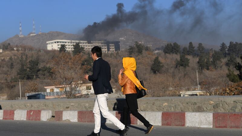 Afghans walk near the Intercontinental Hotel as smoke billows during a fight between gunmen and Afghan security forces in Kabul on January 21st. Photograph: Wakil Kosar/AFP/Getty Images