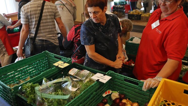 A German woman (C), who preferred not to reveal her name but who said she is unemployed since she became ill, chooses groceries at the food distribution point. Photograph: Sean Gallup/Getty Images