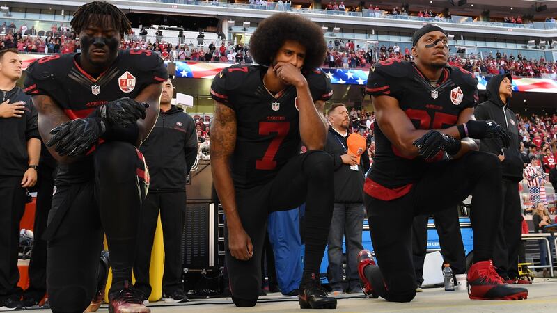 Colin Kaepernick (centre): refused to stand for the national anthem in support of the Black Lives Matter protest – a move that has effectively stalled his career.