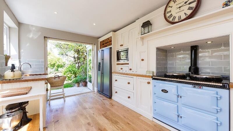 The  kitchen/breakfastroom has the feel and look of a very pleasant sunroom, with a kitchen Aga, in an interesting pale blue colour,  set into an old chimney breast