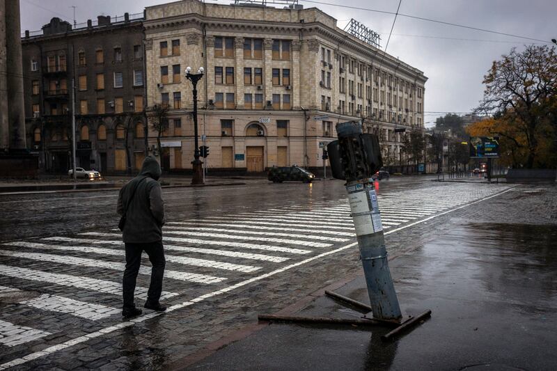 A man walks past a Russian rocket embedded in the asphalt on a nearly-deserted street in Kharkiv. Photograph: Ivor Prickett/ The New York Times