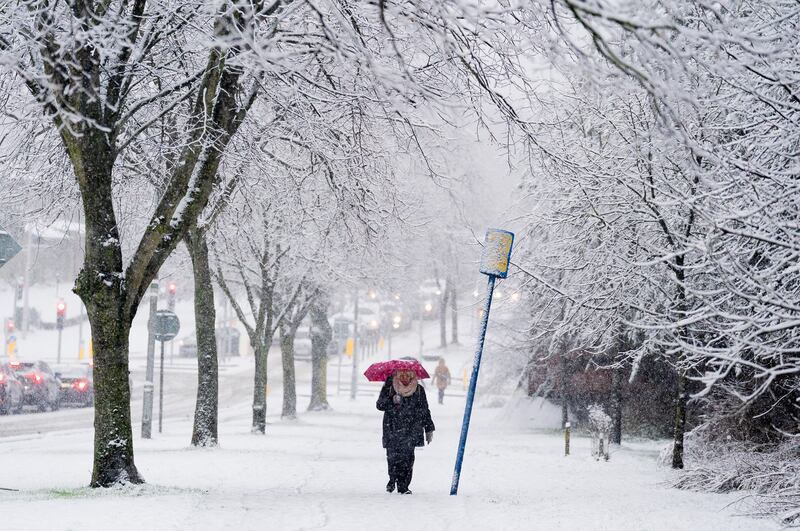 A person uses an umbrella for shelter on Griffith Avenue as snow falls on the Northside of Dublin. Photograph: Brian Lawless/PA Wire
