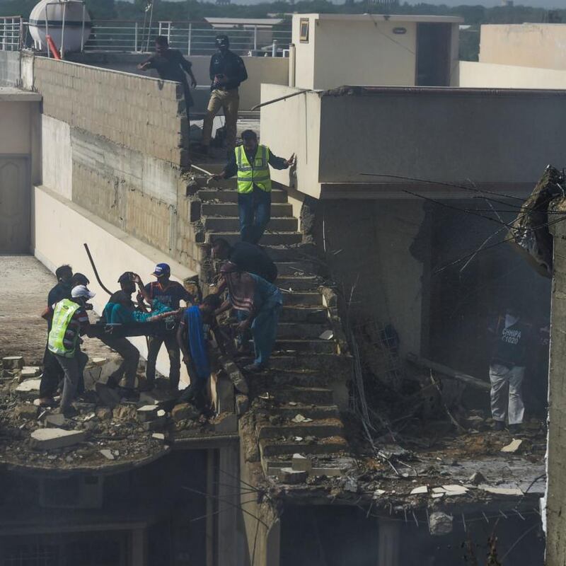 Rescue workers evacuate the site after a Pakistan International Airlines aircraft crashed in a residential neighbourhood in Karachi. Photograph: Asif Hassan/AFP/Getty Images