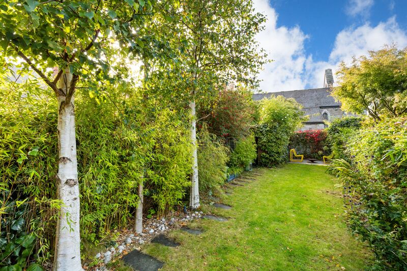 The south-facing back garden has trees and plants down both sides
