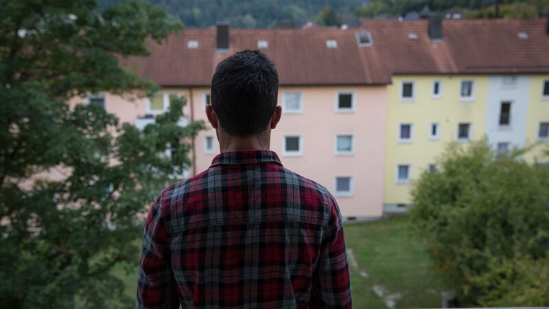 A refugee looks out from the accommodation he shares in Germany with three other Syrians. He came to Europe in a group of eight friends; at least one has attempted to return to Syria so far. Photograph: Sally Hayden
