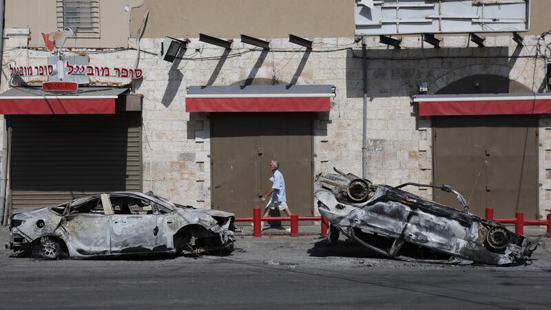 A man walks past burned-out cars following overnight riots between Arab and Jewish residents in Lod, on Wednesday. Photograph: Abir Sultan/EPA