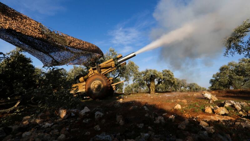 Turkish-backed rebel fighters fire a howitzer toward Syrian government’s forces positions near the village of Neirab in Idlib province. Photograph: AP Photo/Ghaith Alsayed