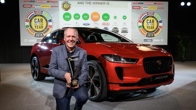 Jaguar design director Ian Callum poses next to a Jaguar I-Pace awarded European Car of the year 2019