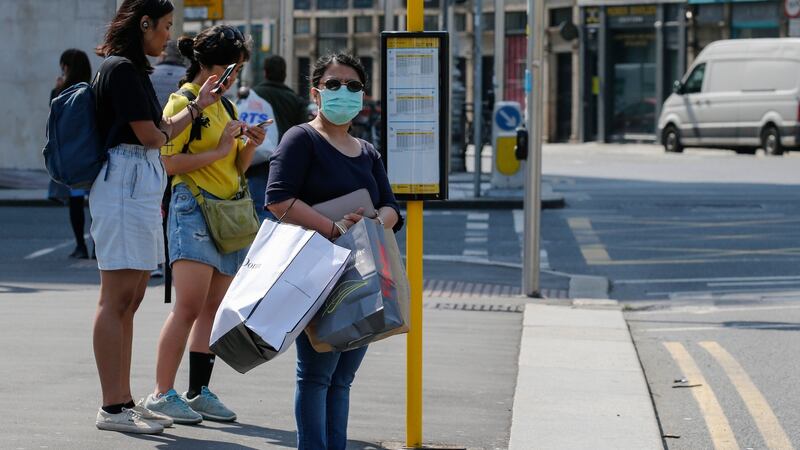 A woman wearing a mask waits for a Dublin Bus. Photograph: Crispin Rodwell/ The Irish Times
