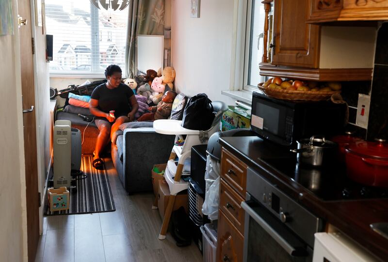Andile Ndhlovu with her 18-month-old son Timmy in their apartment. The cramped living space has mould and water damage to the floors. Photograph: Alan Betson / The Irish Times
