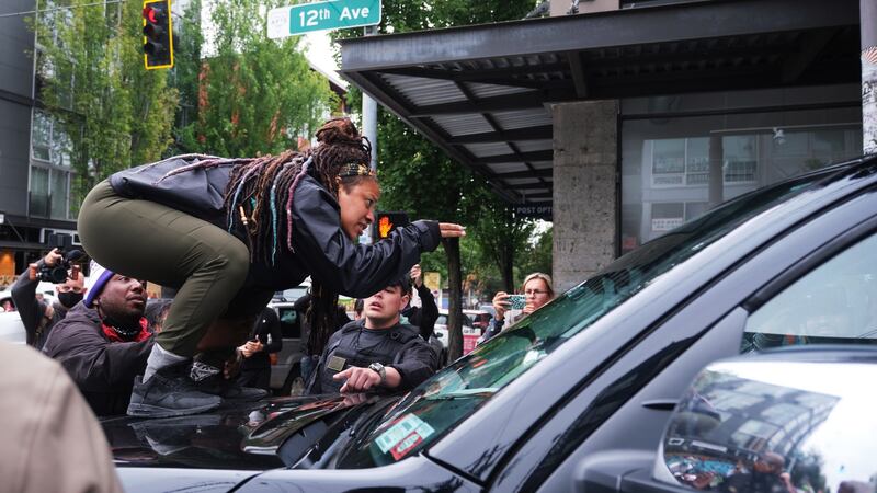 A protester stands on the hood of a truck during a confrontation with a Fox News television crew in Seattle, Washington. Photograph:  Stephen Brashear/EPA