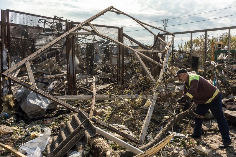A municipal worker cleaning up debris following a Russian missile attack in the Darnytskyi district of Kyiv, Ukraine, on Thursday. Photograph: Brendan Hoffman/New York Times
                      