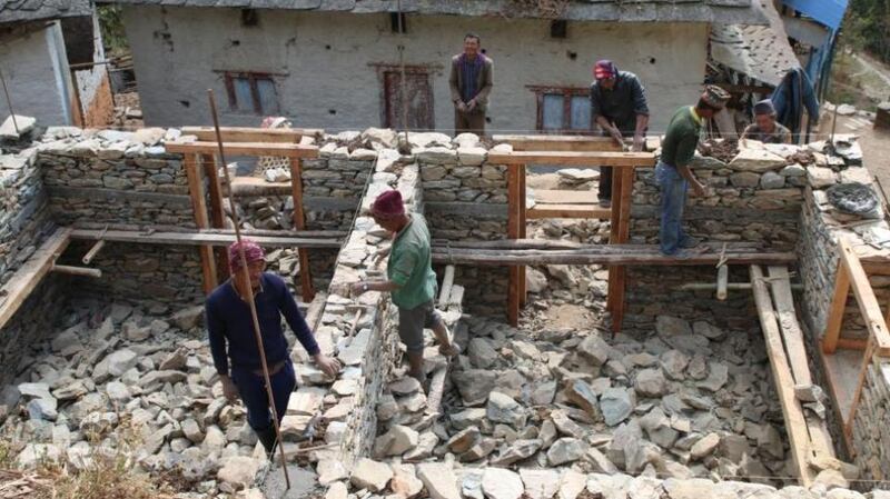 Masons work on the reconstruction of a house in the rural area of Bijulikot, Ramechhap, in Nepal, following the April 2015 earthquake.