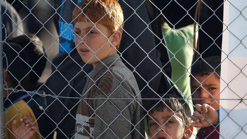 Displaced Iraqi boys who had fled the Islamic State stronghold of Mosul at a fence at Hassan Sham camp, east of Mosul, Iraq, December 27th, 2016. Photograph: Khalid al Mousily/Reuters