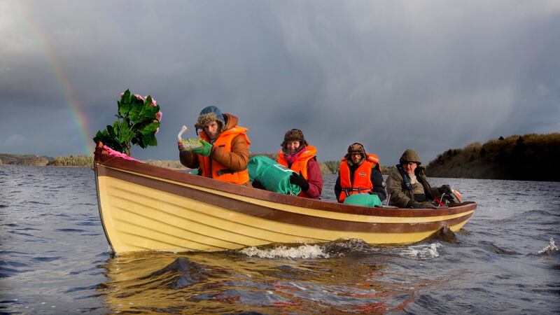 Colum Stapleton, Jessica Reid and Renato Mela are ferried from Trinity Island on Lough Key   by Finian Dodd, during the ceremonial transfer of the annals  on Monday. Photograph: Brian Farrell