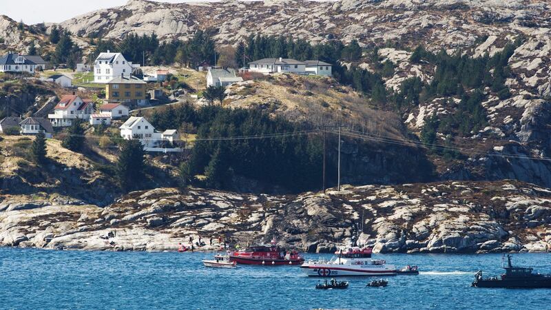 A search and rescue vessel is seen  off the island of Turoey, near Bergen, Norway, as emergency workers on the shoreline attend the scene of a  helicopter crash on  Friday. Photograph: AP