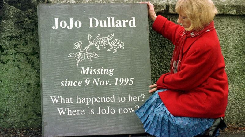 A file image from 1998 of  Mary Phelan, the sister of Jo JO Dullard, with a memorial stone at the side of the road near the phone box where  Jo Jo made her last call home and was last sighted, in Moone Co Kildare. Photograph: John Cogill