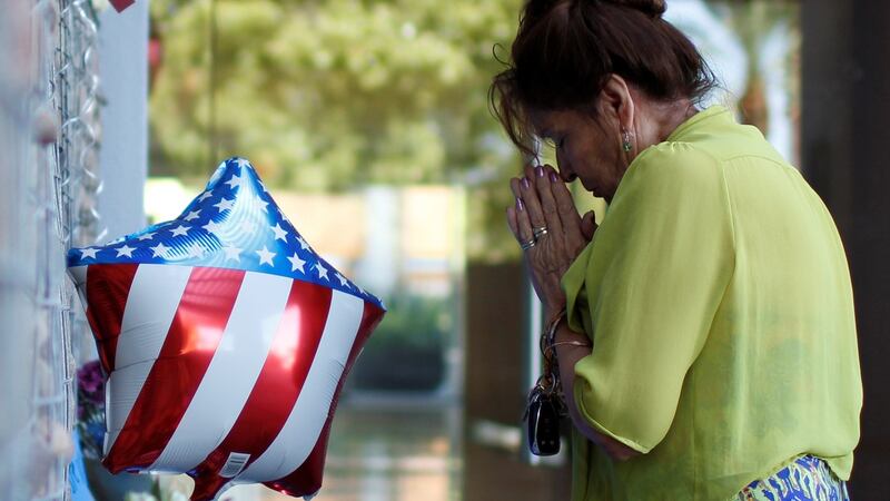 Maria Vicllalpando prays in front of a memorial for late US senator John McCain outside his office in Phoenix, Arizona. Photograph: Nicole Neri/Reuters.