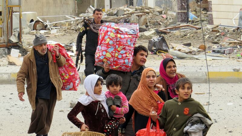 Iraqi government forces and members of Iraq’s elite counter-terrorism service help civilians cross a street during battles with Islamic State jihadis on Monday. Photograph: AFP/Getty Images