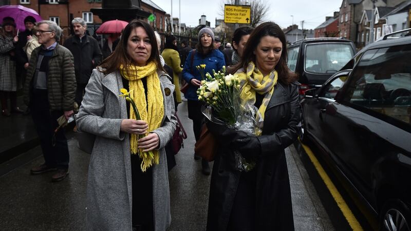 Former school classmates of the Dolores O’Riordan carry yellow flowers to signify sunshine as the late  singer lies  in repose in St Joseph’s Church in Limerick. Photograph: Charles McQuillan/Getty