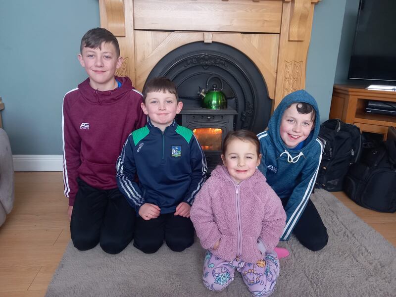 Sean, Jamie, Chloe and Dylan O'Dwyer in front of the solid fuel stove, which is the family's only source of heat over the current cold snap