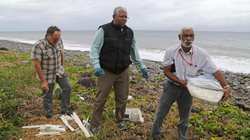 A Malaysian expert (centre) looks for debris from the ill-fated Malaysia Airlines flight MH370 on a beach in Saint-Andre de la Reunion, on the French Reunion Island in the Indian Ocean. Photograph: Richard Bouhet/AFP/Getty Images