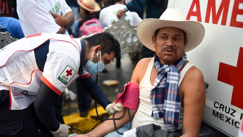 A paramedic checks the blood pressure of a migrant taking part in a caravan heading to the US, at the main square in Tapachula. Photograph: Johan Ordonez/AFP/Getty Images