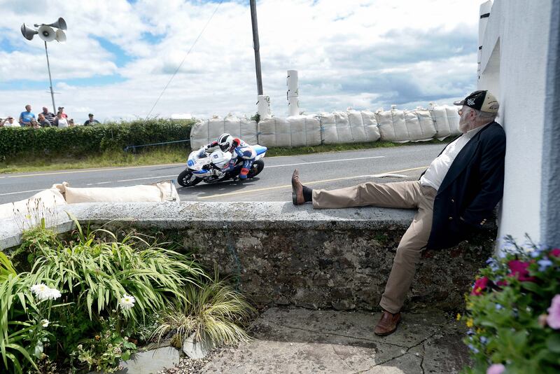 A spectator watches William Dunlop (Tyco Suzuki) on his way to victory in the Supersport race at Walderstown road races in Co Westmeath. Photograph: Stephen Davison
