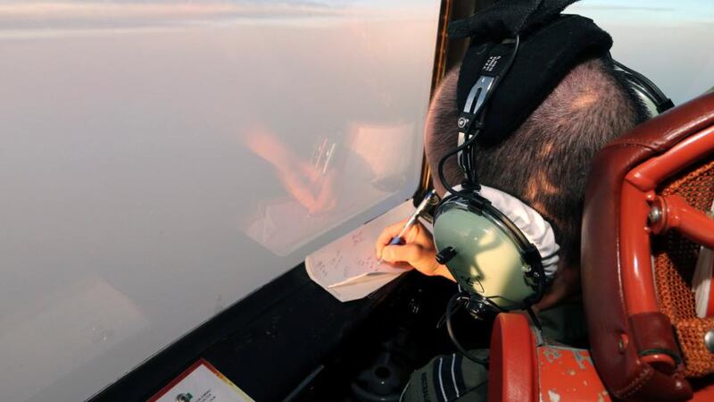 Flight lieutenant Jason Nichols on board a Royal Australian Air Force AP-3C Orion, takes notes as they search for missing Malaysian Airlines flight MH370 debris or wreckage in Southern Indian Ocean today. Photograph: EPA
