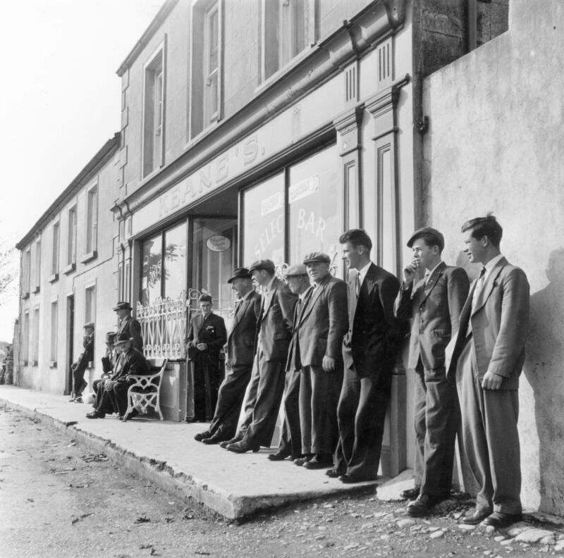 A line of men leaning against the window of Keane's bar in Oranmore, Co Galway. Photo by Haywood Magee/Getty Images