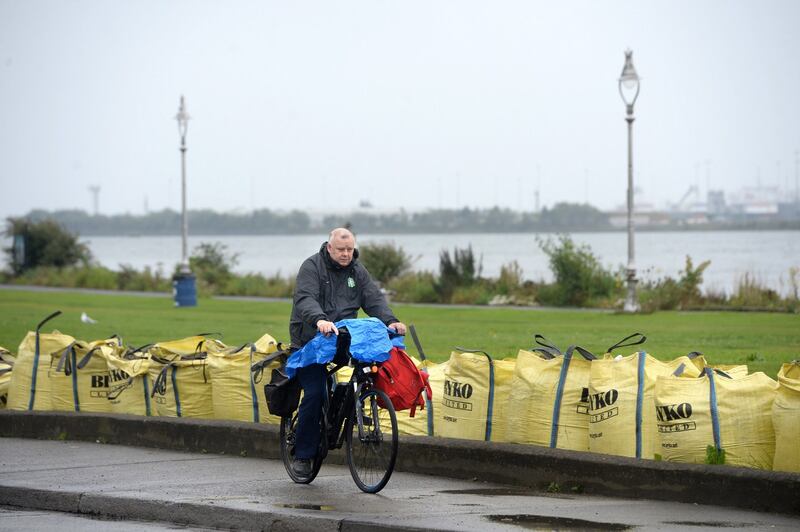 A man cycles past sandbags placed on the Clontarf Road in Dublin in preparation for storm Ellen. Photograph: Dara Mac Dónaill