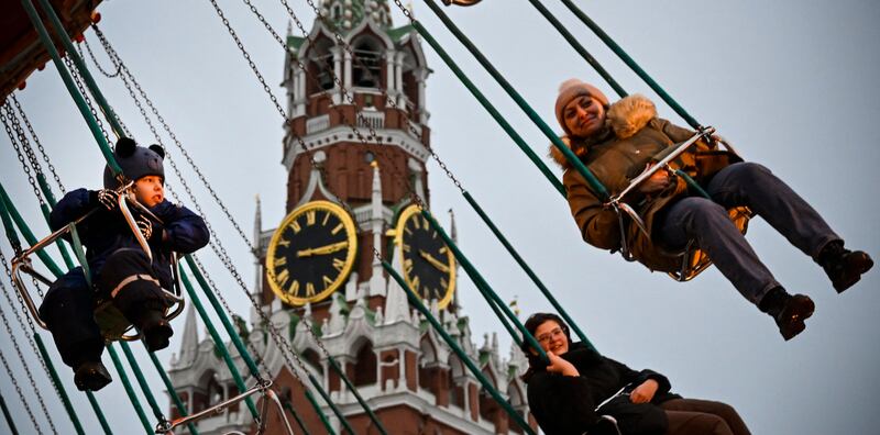 Children and adults enjoy a chair swing ride in front of the Kremlin's Spasskaya Tower on Red Square in Moscow. Photograph: Alexander Nemenov/AFP via Getty Images