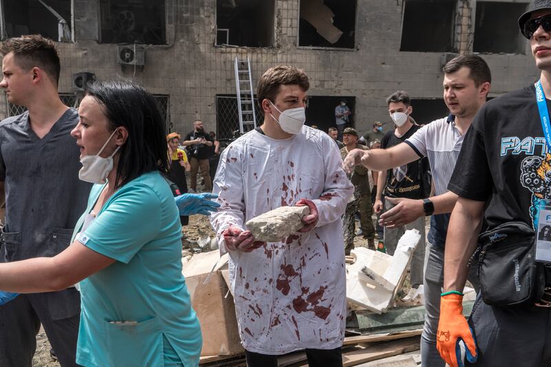 Dr Ihor Kolodka, centre, covered in his own blood, helps others clear rubble after a Russian missile strike on the Ohmatdyt Children's Hospital in Kyiv, Ukraine, July 8th. Photograph: Brendan Hoffman
                      
