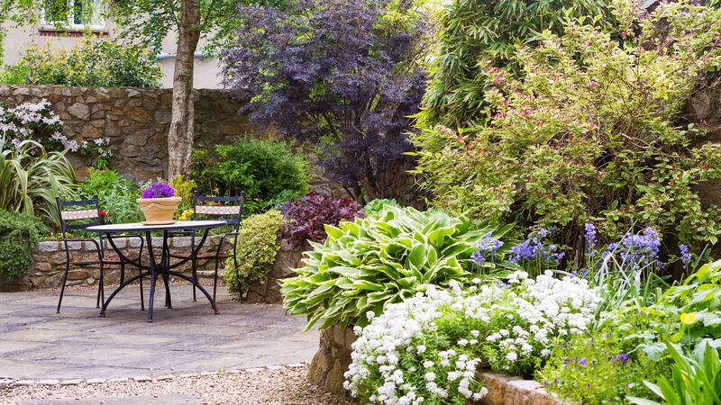 The garden at the back, surrounded by granite walls, with raised colourful flower beds, is relatively small but well landscaped.