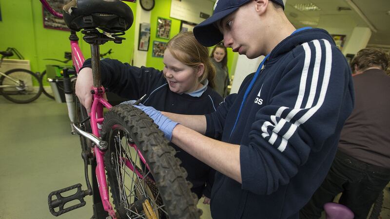 Patrick  and his sister Katelyn repairing her bike at Bradog Youth Service. Photograph: Dave Meehan