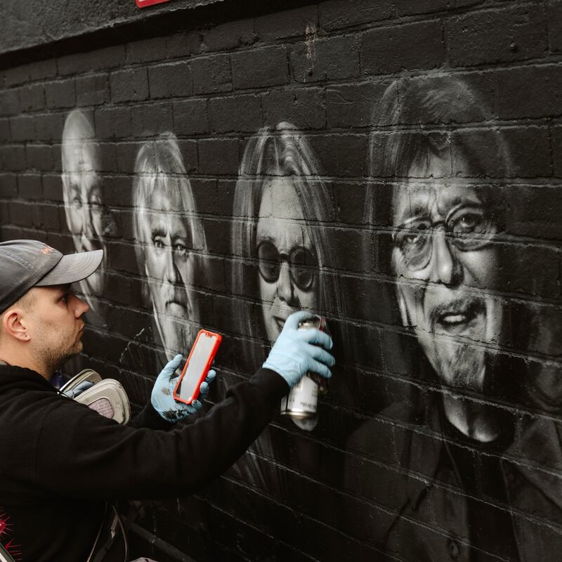 Ozzy Osbourne funeral: a street artist adds to a Black Sabbath mural in Birmingham. Photograph: Joanna Yee/New York Times                     