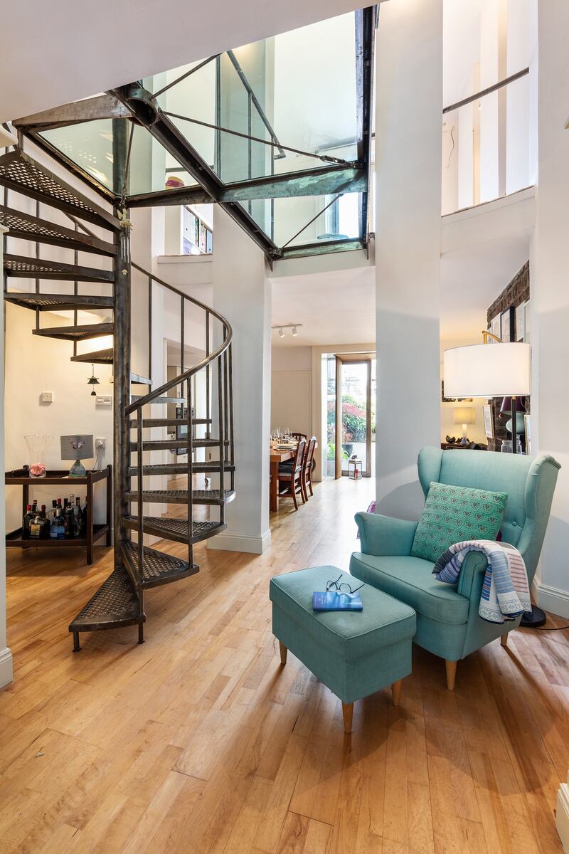 Garden-level unit: spiral staircase and glass-floor bridge above