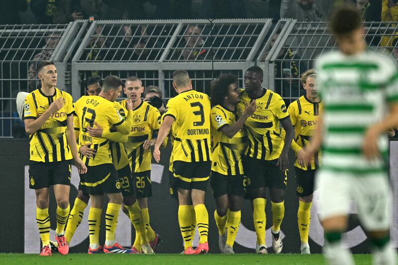 Dortmund's German midfielder Emre Can celebrates with his team mates after scoring his team's first goal from the penalty spot against Celtic. Photograph; Ina Fassbender/AFP/Getty Images