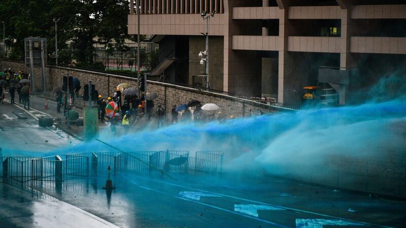 Police fire a water cannon towards protesters near the government headquarters in Hong Kong. Photograph: Getty
