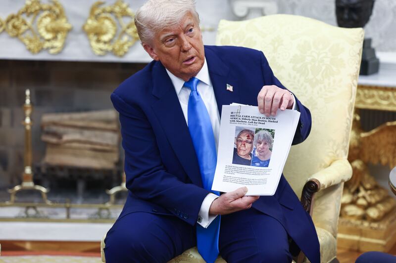 Donald Trump holds up news articles allegedly related to violence in South Africa. Photograph: EPA