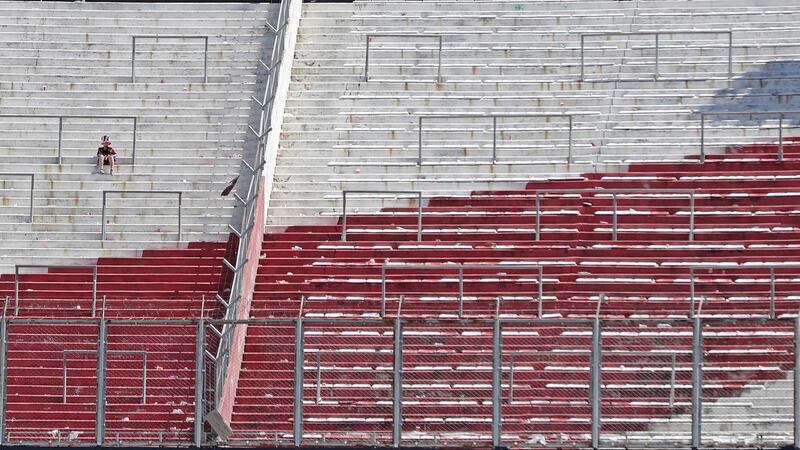 A supporter of River Plate sits on an empty stand after the game had been postponed. Photo: Alejandro Pagni/Getty Images