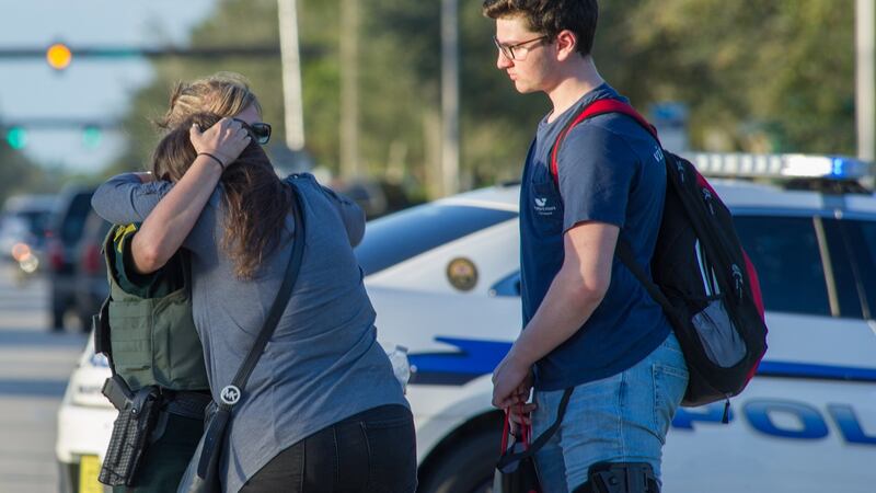 A woman is comforted by police after a shooting at Marjory Stoneman Douglas High School in Florida. Photograph: EPA