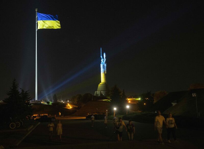 A Ukrainian national flag fluttering next to the Motherland monument illuminated in Kyiv. Photograph: Genya Savilov/AFP