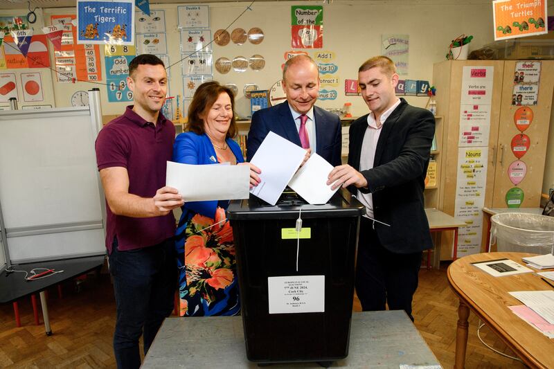 Tánaiste Micheál Martin with his wife Mary and sons Micheál Aodh and Cillian cast their votes at St Anthony's Boys National School in Ballinlough, Cork on Friday. Photograph: Daragh Mc Sweeney/Provision