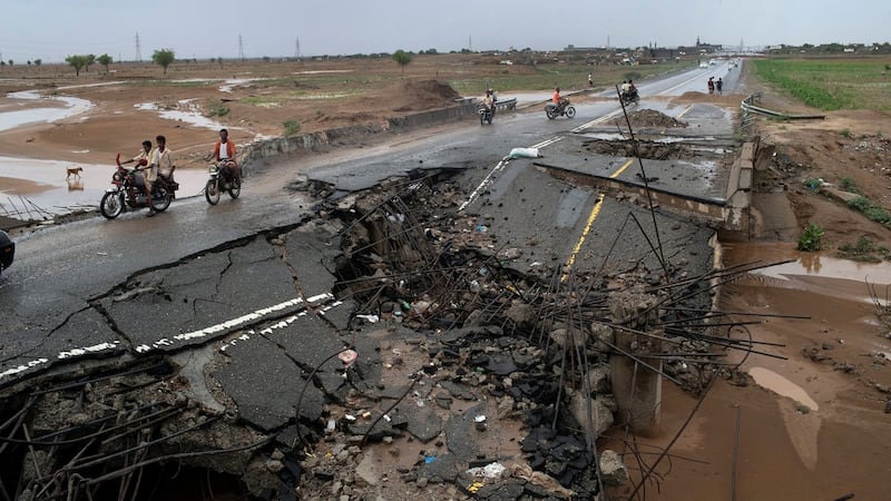 Motorcycles and cars driven across a damaged bridge in Bani Hassan, Yemen.  Photograph: Tyler Hicks/The New York Times